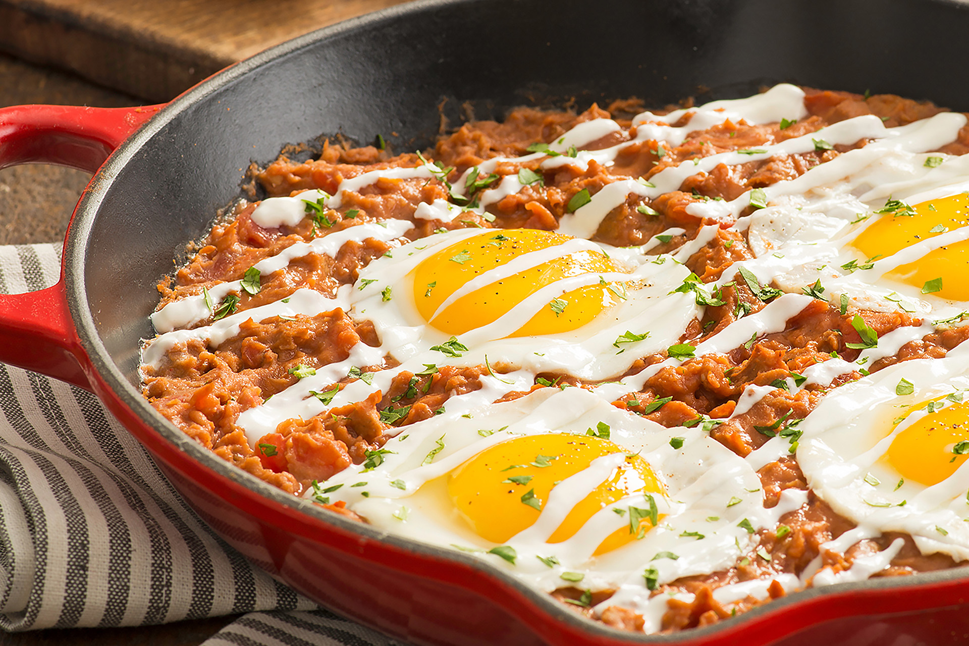 Refried bean, chorizo and tomato skillet topped with sunny side up eggs