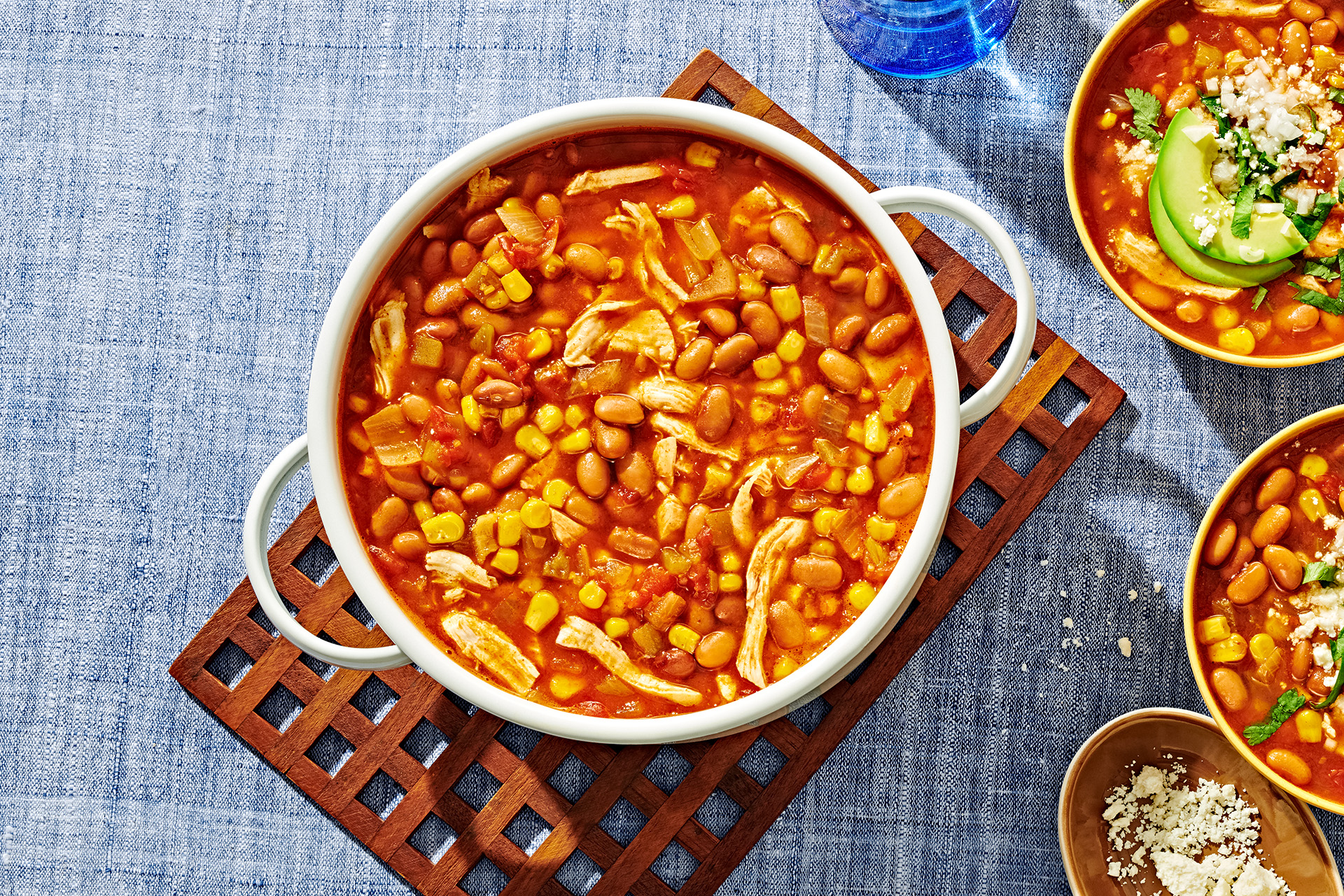 Chicken tortilla soup with beans in a white pot