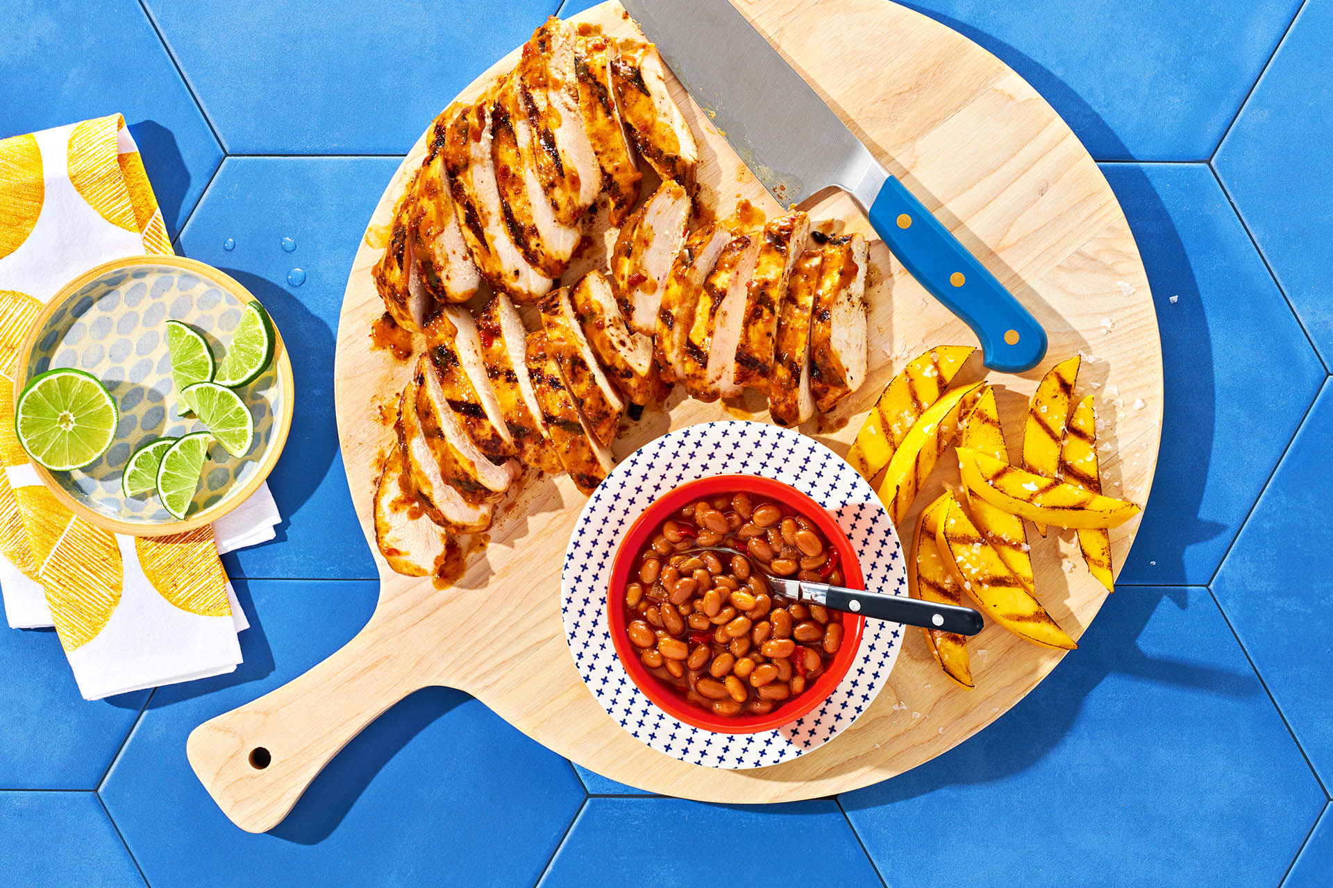 Wood platter with Mango Chipotle Chicken and a side of beans.