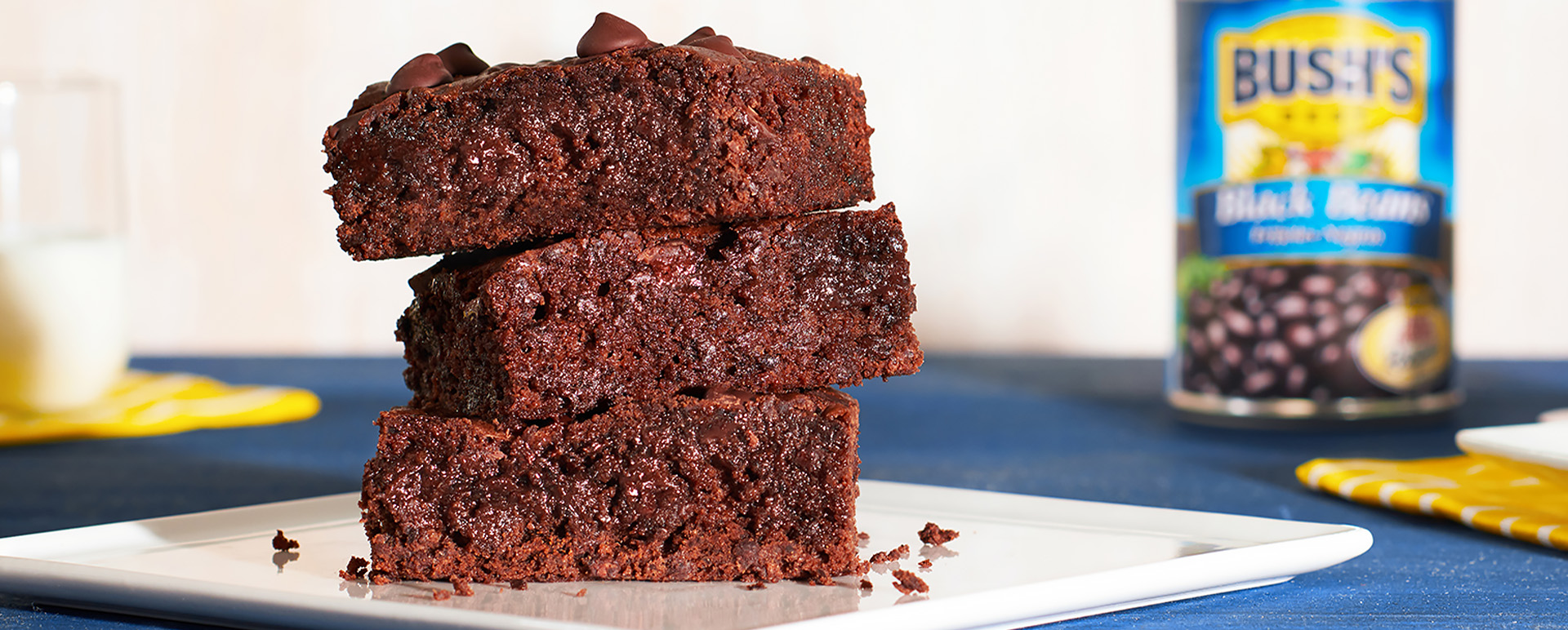 A close-up of three black bean and dark chocolate brownies stacked on top of each other